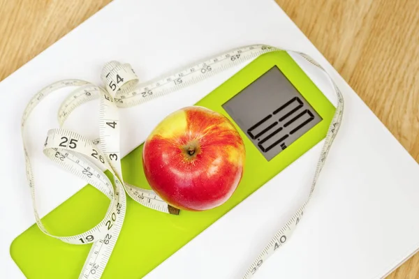 Apple with measuring tape close up on digital scale — Stock Photo, Image