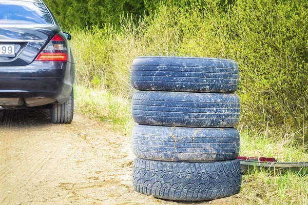 Куча шин, сложенных на дороге в лесу — стоковое фото