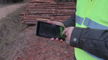 Oduncu günlük kazık yakınındaki tablet kullanma