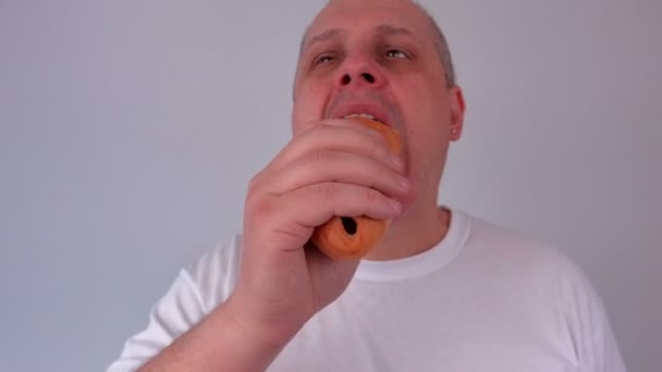 Mannelijke hotdog eten en het houden van digitale weegschaal — Stockvideo