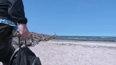 Deniz kenarında plajda tek başına duran ellerini adamla