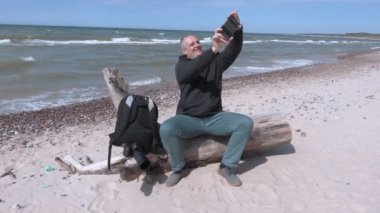 Mutlu bir adam sahilde deniz kenarında selfie al