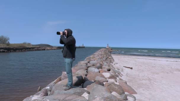 Фотограф-путешественник фотографирует на пристани — стоковое видео