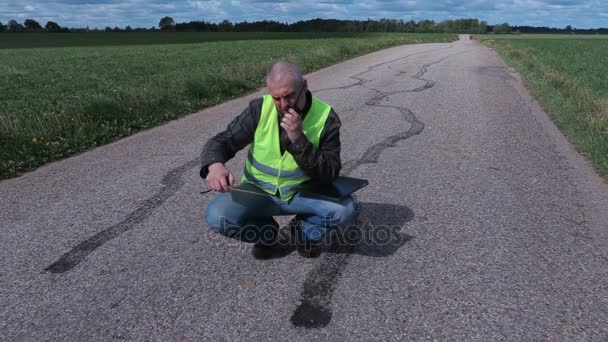 Inspector using tape measure near tire marks on road — Stock Video