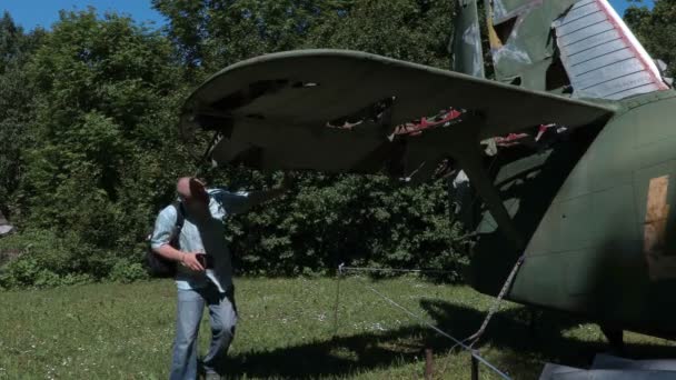 Турист возле старого самолета — стоковое видео