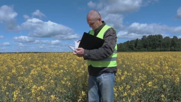 Фермер на рапсовом поле, страдающий аллергией — стоковое видео