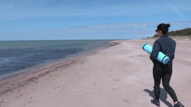 Fitness woman with workout mat near sea — Stock Video