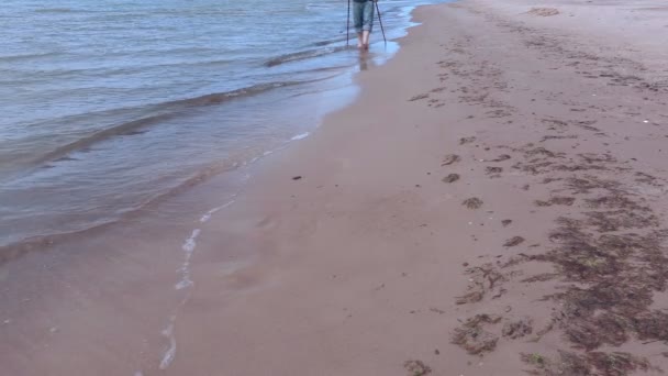 Mannen med vandringsstavar promenader längs kanten av havet — Stockvideo