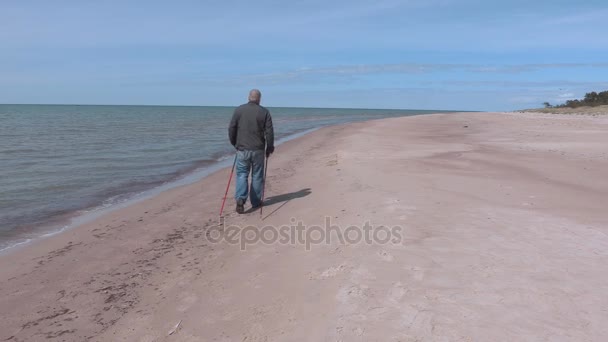 Runner kobieta i turysta z kijki turystyczne na plaży, w pobliżu morza — Wideo stockowe