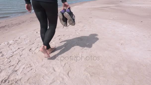 Femme aux pieds nus marchant sur la plage — Video