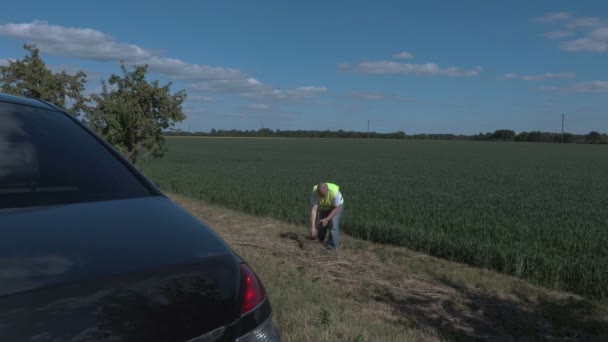 Agricultor en el campo cerca de coche — Vídeos de Stock