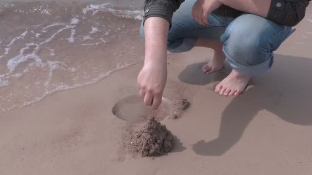 Hombre construido castillo de arena cerca del mar — Vídeos de Stock