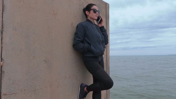 Mujer hablando por teléfono en embarcadero cerca del mar — Vídeos de Stock