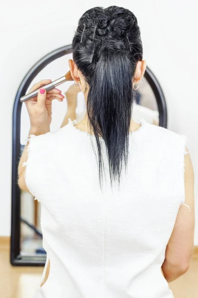 Kvinna med makeup borste nära spegel — Stockfoto