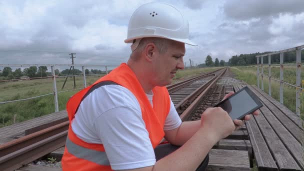 Spoorweg werknemer met behulp van tablet Pc op de spoorbrug — Stockvideo