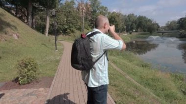 Adam parkta fotoğraf makinesinde fotoğraf çekmek