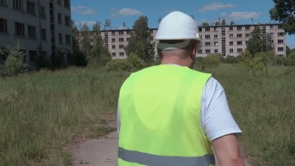 Constructor va y habla de casas de apartamentos abandonados — Vídeo de stock