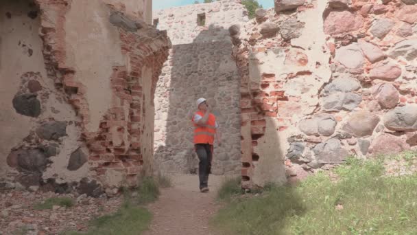 Costruttore esaminato le rovine di un vecchio castello — Video Stock