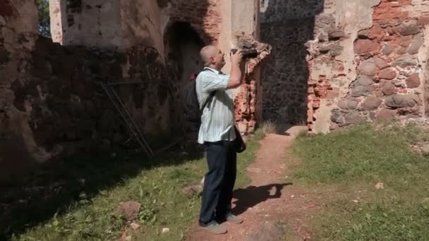 Hombre con cámara fotográfica en ruinas de castillos viejos — Vídeos de Stock