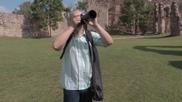 Турист фотографирует на фотокамеру во дворе замка — стоковое видео