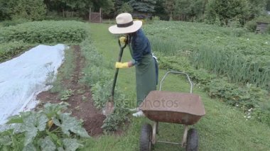 Kadın bahçıvan kürek kürek el arabası kullanma