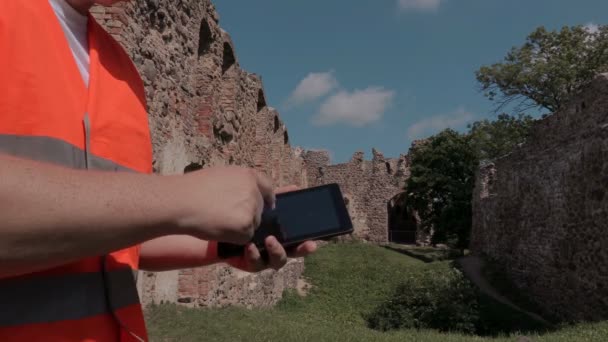 Constructor usando tableta en el patio del castillo — Vídeos de Stock