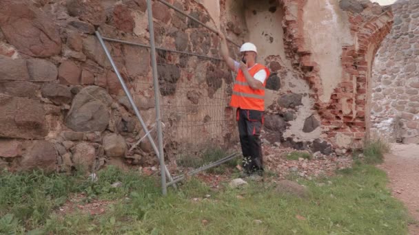 Bauarbeiter benutzte Walkie Talkie in der Nähe von Zaun — Stockvideo