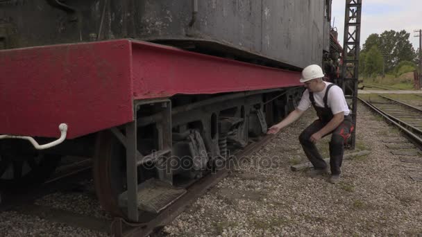 Железнодорожник проверяет колеса — стоковое видео