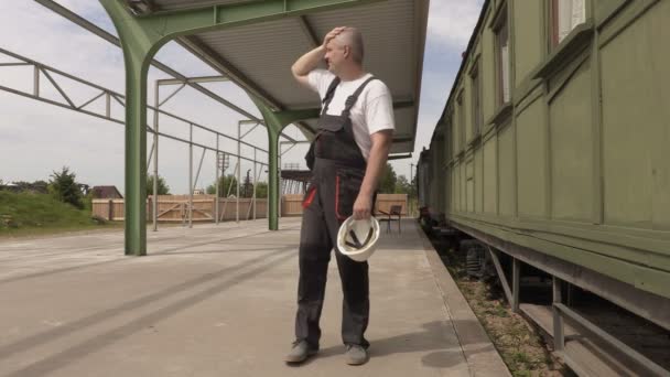 Stressvolle arbeider op het station bij de wagons — Stockvideo