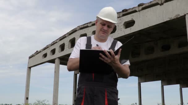 Technik píše nedokončené budovy — Stock video