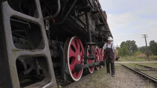 Železniční zaměstnanec kontroluje lokomotiva — Stock video