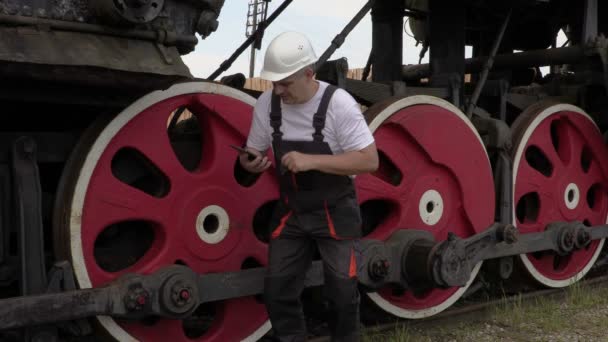 Spoorweg werknemer op de locomotief loopwerk — Stockvideo
