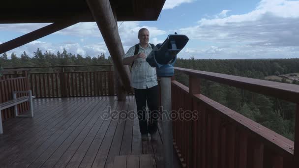 Turista llega a los prismáticos en la torre de vista — Vídeos de Stock