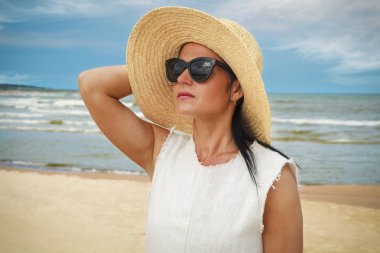 Sahilde hasır şapkalı kadın