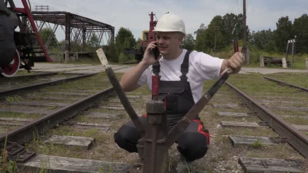 Järnvägen anställd talar via telefon på växlarna — Stockvideo