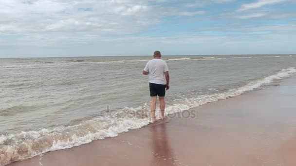 El hombre se adentra más en el mar — Vídeo de stock