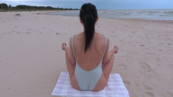 La mujer medita junto al mar — Vídeos de Stock