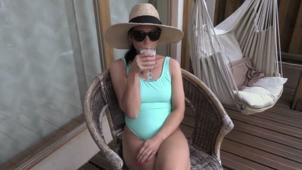 Mujer sentada y bebiendo cóctel — Vídeo de stock