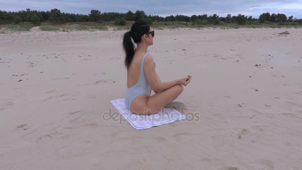 Femme médite sur la plage près de la mer — Video