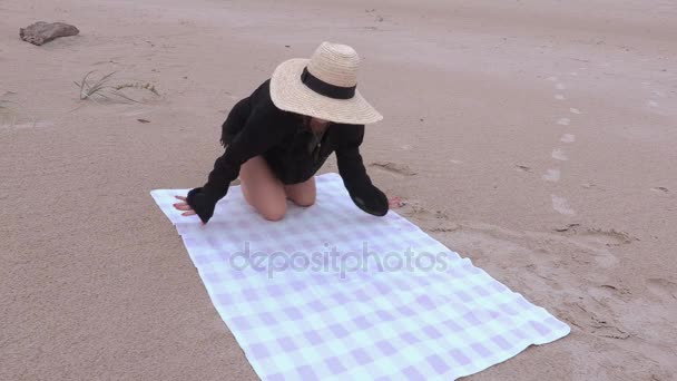 Mujer se sienta en la toalla de playa — Vídeo de stock