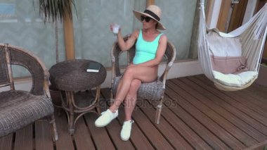 kadın bir kokteyl bungalov içecekler.