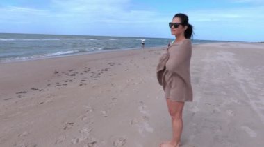 Denize yakın battaniye sarılı kadın