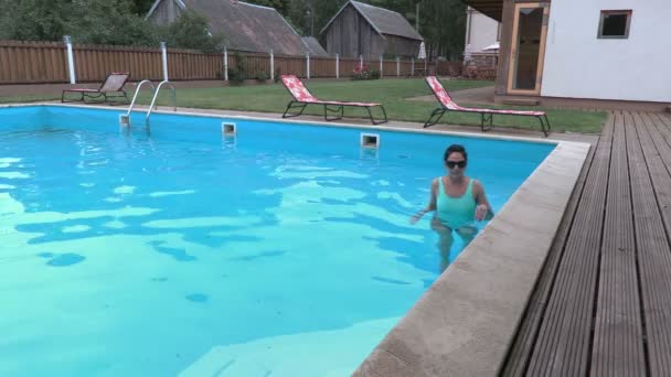Kvinna kommer ur poolen — Stockvideo