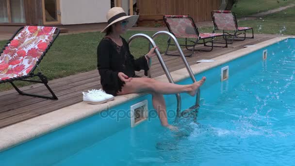 Frau planscht im Pool am Wasser — Stockvideo