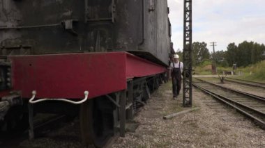 Demiryolu çalışanı üzerinde lokomotif tırmanıyor