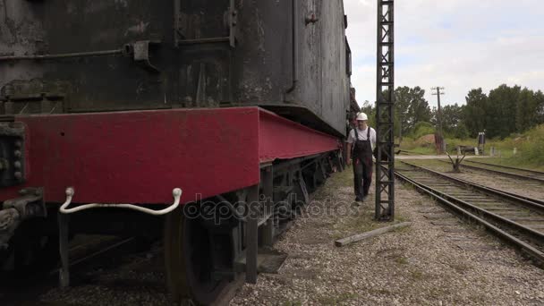 Spoorweg werknemer klimt op de locomotief — Stockvideo