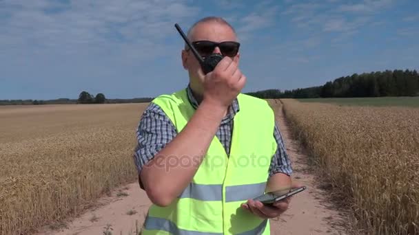 Boer op granen veld met walkie talkie — Stockvideo