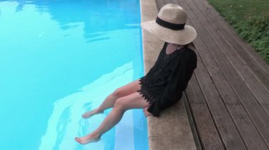 Hasır şapka rahatlatıcı Yüzme Havuzu kenarında kadın
