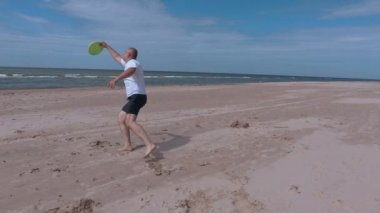 Adam frizbi disk sahilde rahatlatıcı