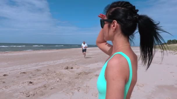 La femme regarde la mer et l'homme qui court — Video